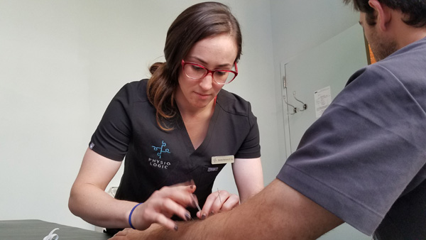 Dr. Allison Heffron treating patient with acupuncture for elbow pain