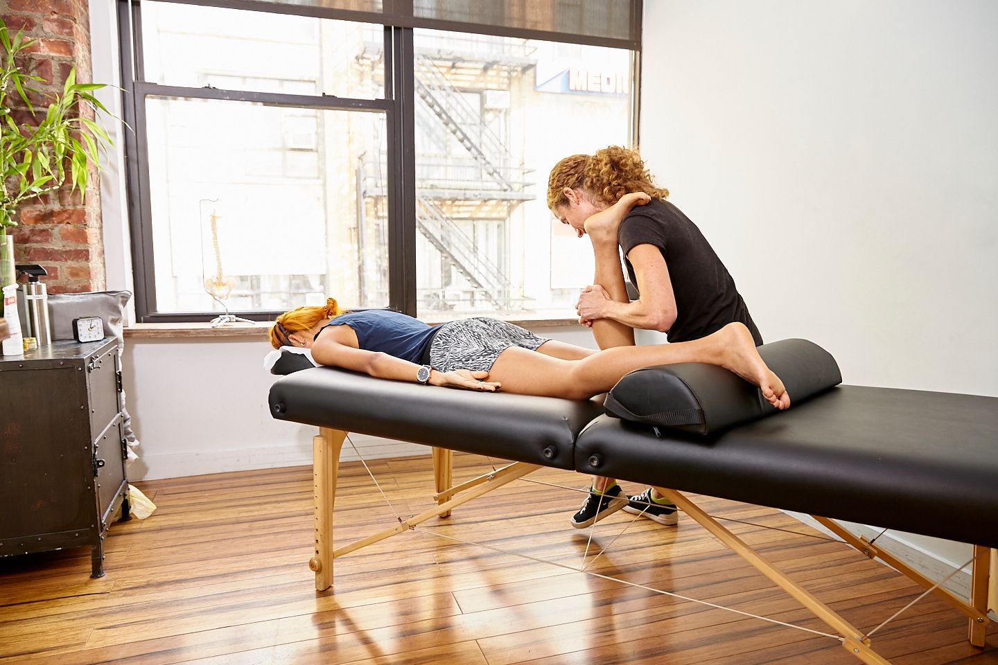 Amy Montia, PhD, LMT performing medical massage therapy for sciatic nerve pain relief at Physio Logic NYC in Brooklyn, NY.