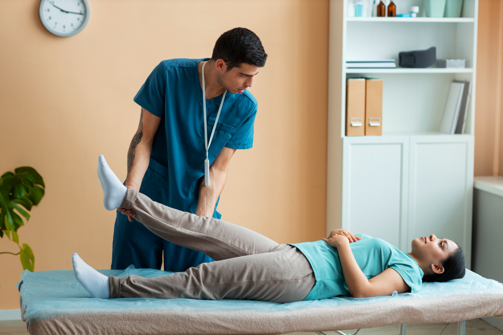 Pelvic floor physical therapy session in NYC with therapist assisting patient in leg stretch on treatment table.